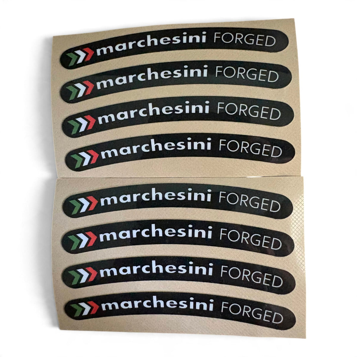 Two sheets of curved black stickers with the brand name 'marchesini FORGED' in white, each sheet containing six stickers, on a white background.